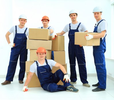 Local movers carrying furniture through a Pimlico apartment building